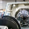Mitarbeiter bedient CNC-Maschine im Sondermaschinenbau mit individuell gefertigter Drehvorrichtung in moderner Produktionshalle