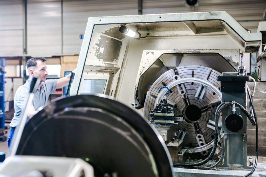 Mitarbeiter bedient CNC-Maschine im Sondermaschinenbau mit individuell gefertigter Drehvorrichtung in moderner Produktionshalle